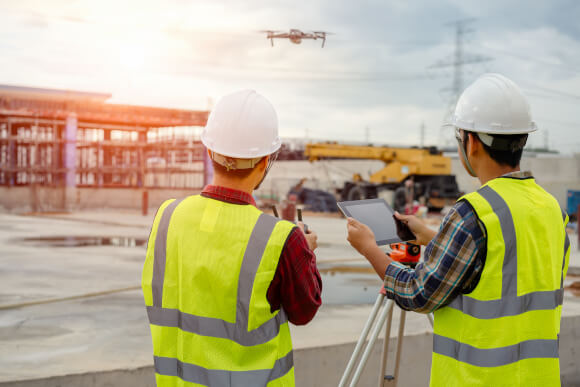Construction Professionals Using Drone and Tablet for Property Analysis Construction Professionals Using Drone and Tablet for Property Analysis