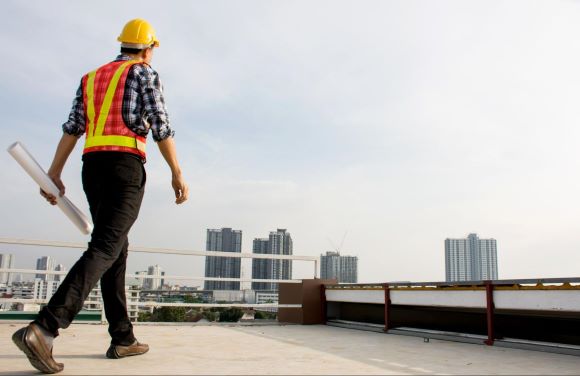 Construction Technician Looking Out Over Tall Building Construction Technician Looking Out Over Tall Building