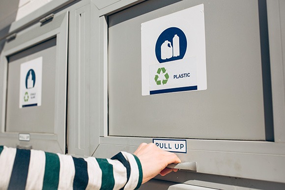 Hand opening a trash chute door Hand opening a trash chute door